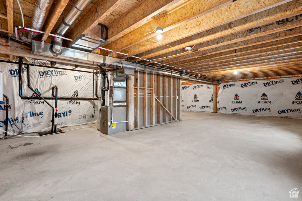 Unfinished basement featuring heating unit