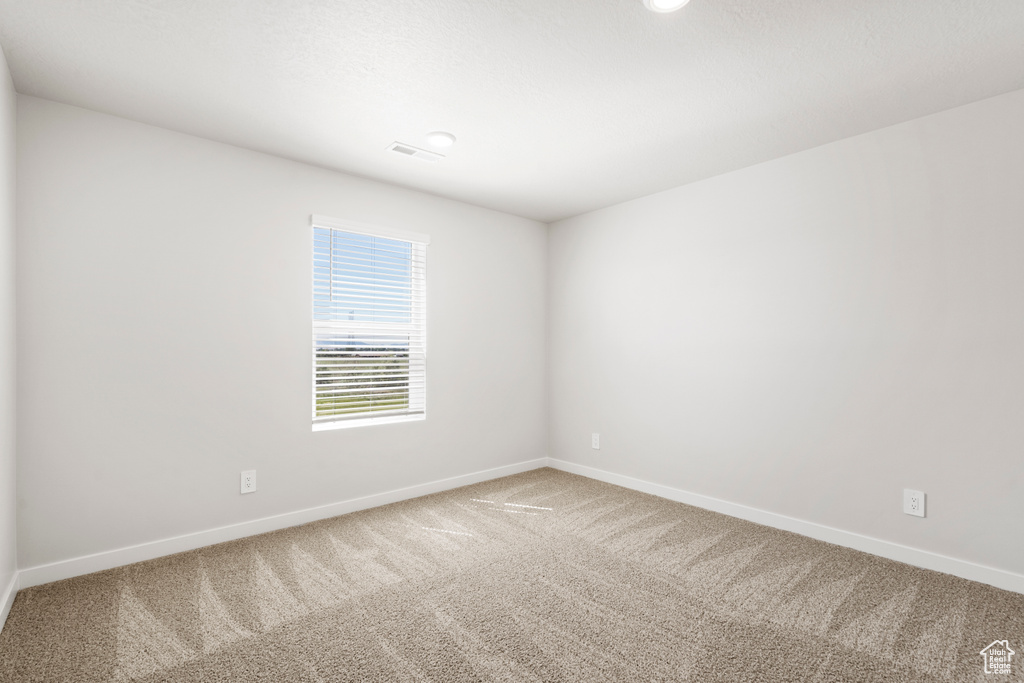 Carpeted empty room featuring baseboards
