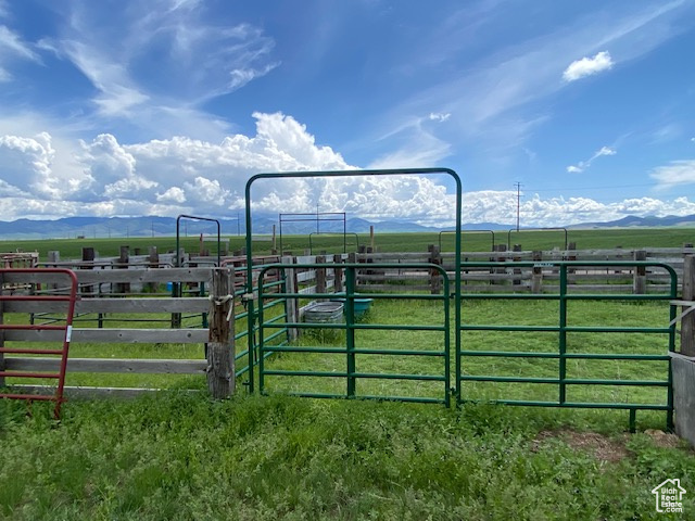 View of gate with a rural view, a mountain view, and an exterior structure