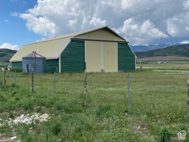 View of pole building featuring a mountain view and fence