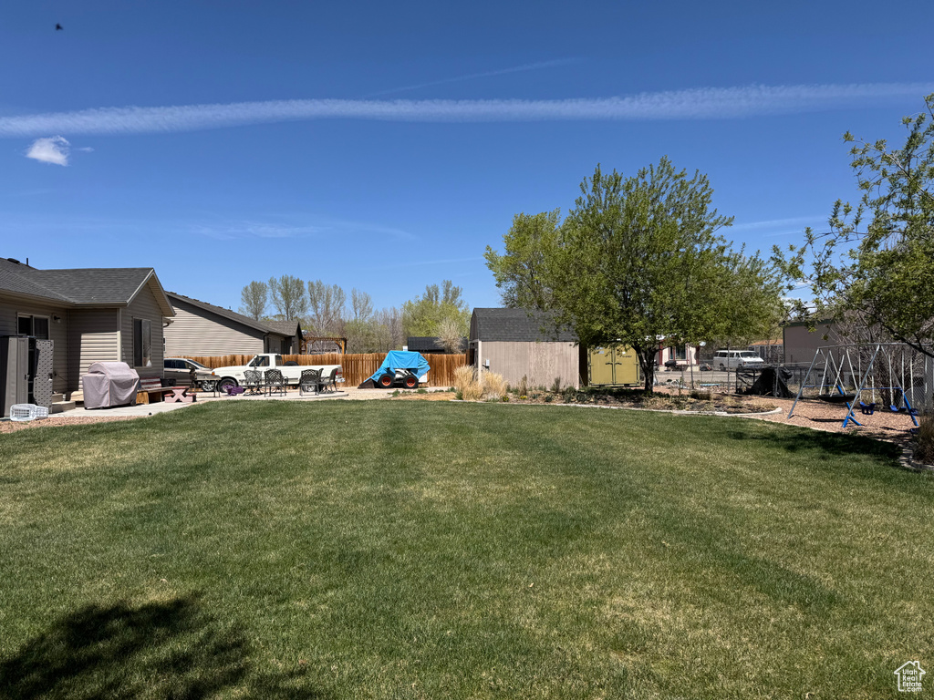 View of yard featuring fence, a patio area, and a playground