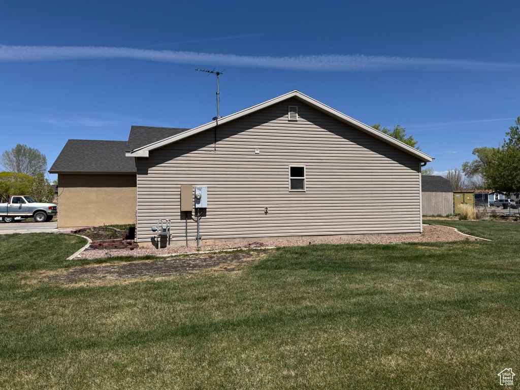 View of side of home with a yard