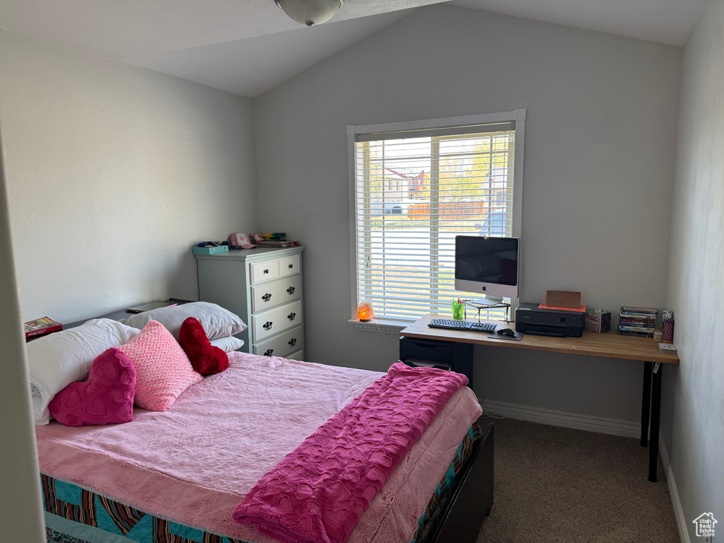 Bedroom featuring vaulted ceiling, baseboards, and carpet floors