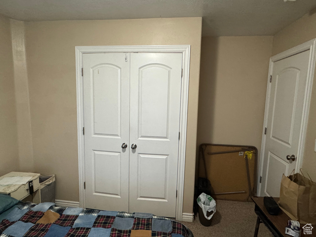 Carpeted bedroom featuring a closet and baseboards