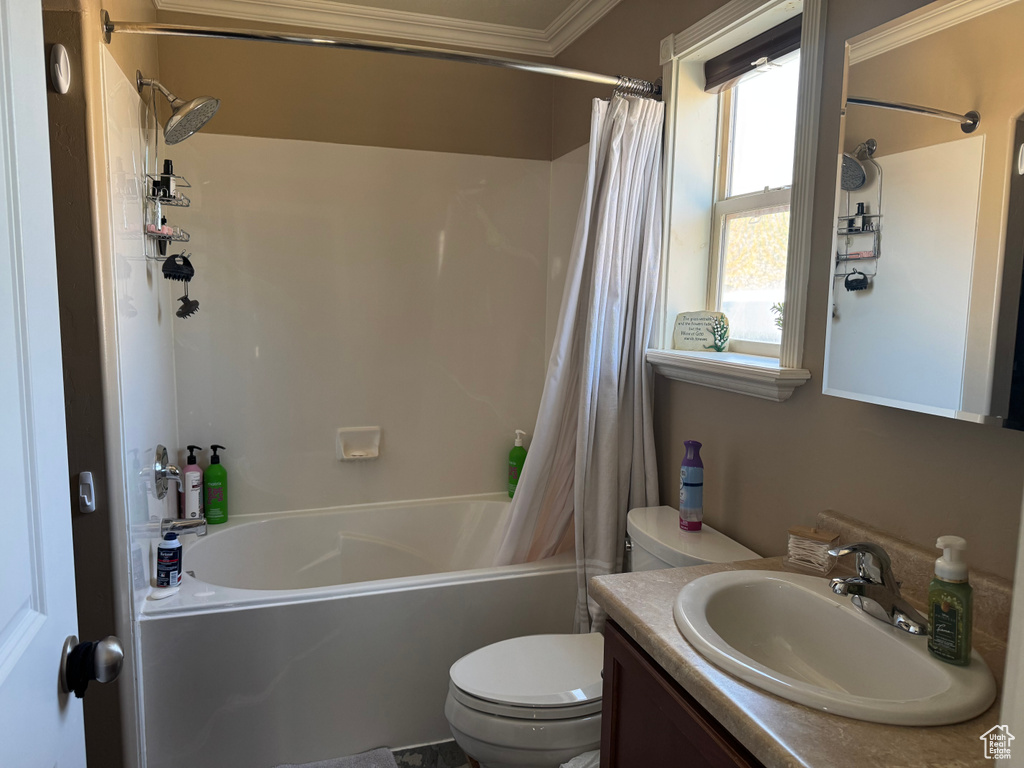 Bathroom with toilet, crown molding, vanity, and shower / bathtub combination with curtain