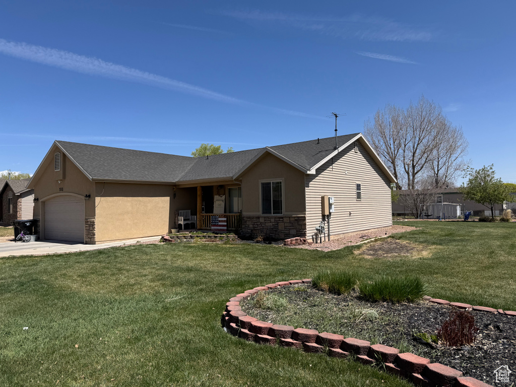 Single story home featuring stone siding, a front lawn, stucco siding, and a garage