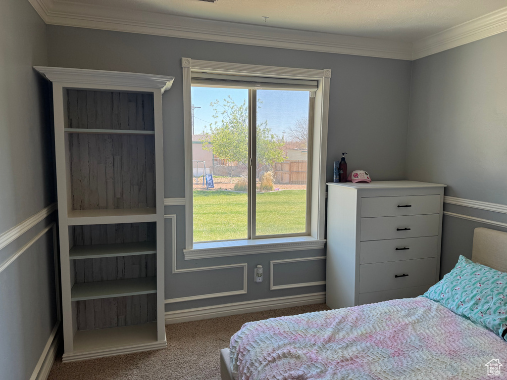 Carpeted bedroom with ornamental molding