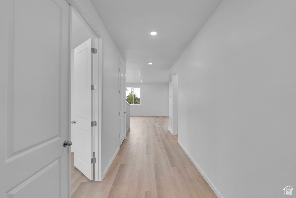 Hall with light wood-style flooring, recessed lighting, and baseboards