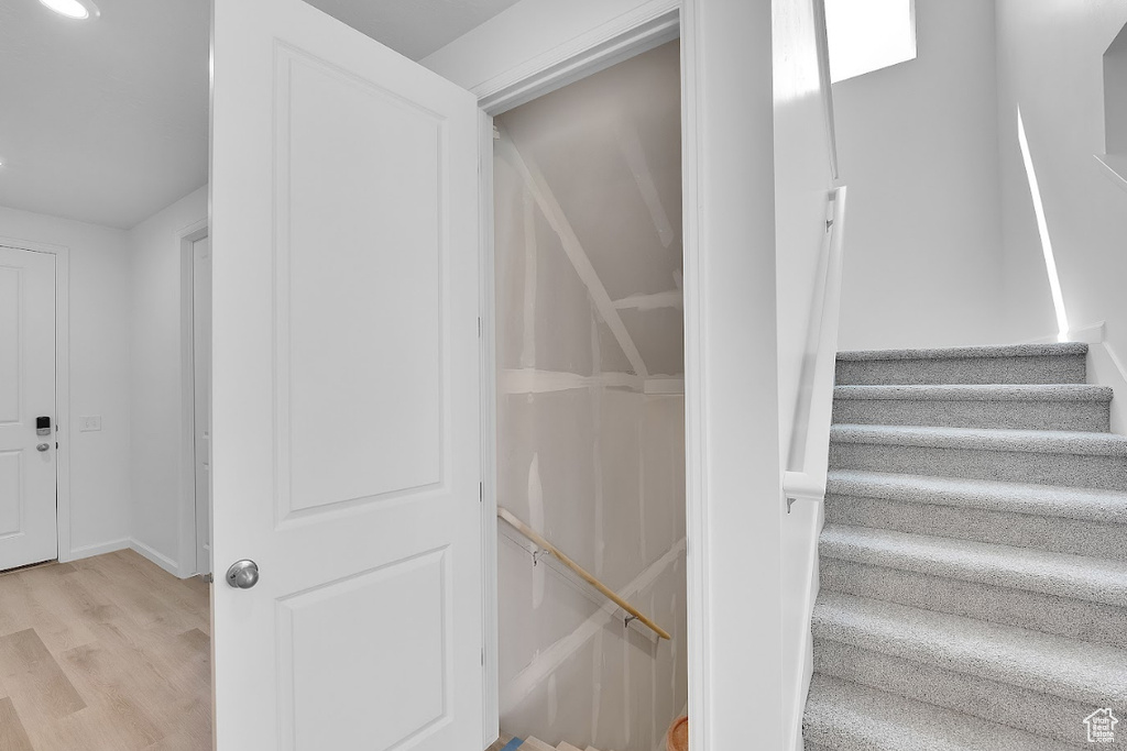 Stairs featuring wood finished floors and baseboards