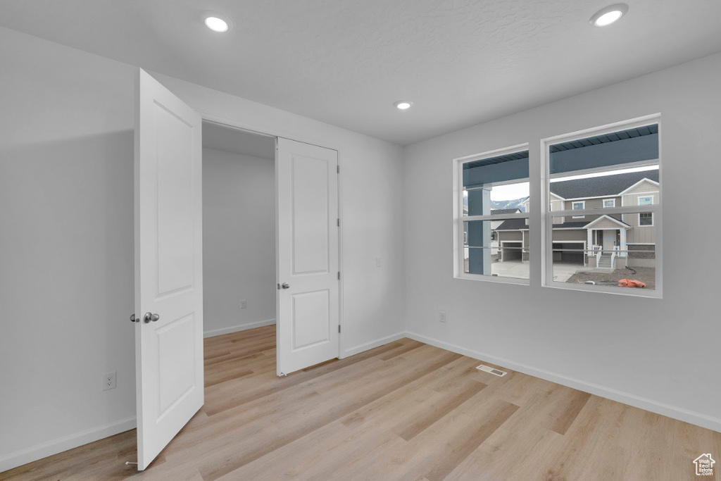 Spare room with light wood-style flooring, baseboards, and recessed lighting