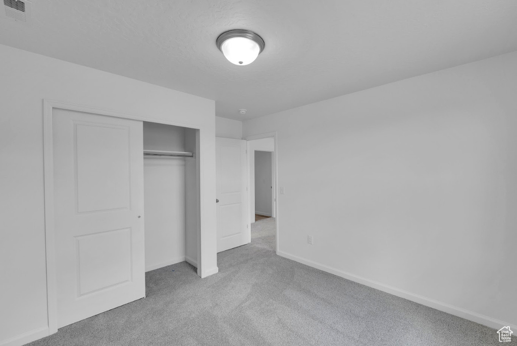 Unfurnished bedroom with carpet floors, baseboards, and a closet