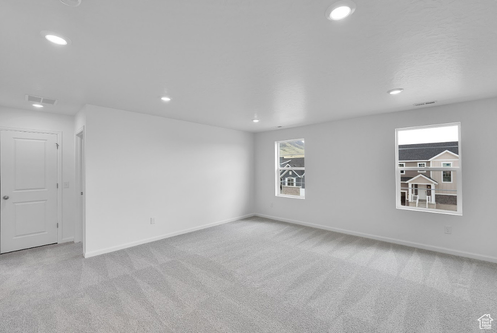 Carpeted spare room with recessed lighting and baseboards