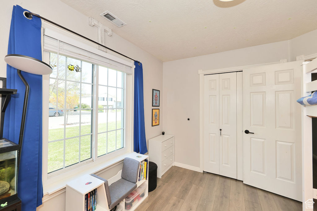 Interior space featuring baseboards, wood finished floors, visible vents, and plenty of natural light