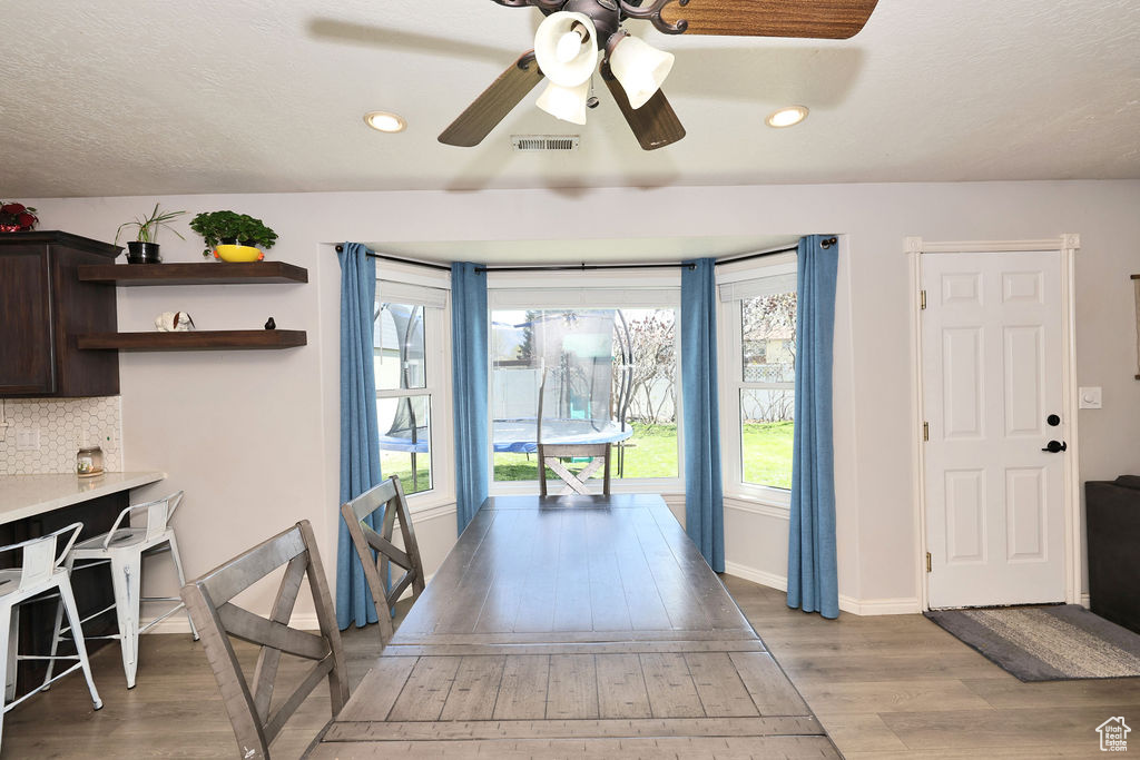 Interior space featuring light wood-style flooring, visible vents, a wealth of natural light, and a ceiling fan