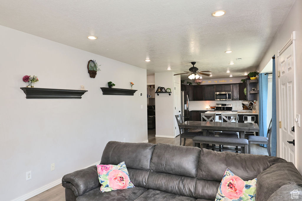 Living area featuring recessed lighting, wood finished floors, baseboards, and ceiling fan