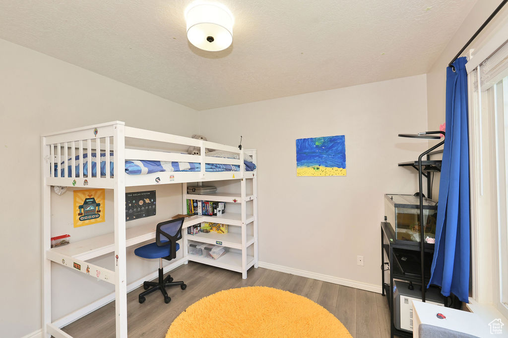 Bedroom featuring baseboards and wood finished floors