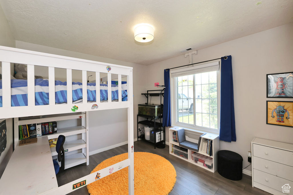 Bedroom featuring baseboards, wood finished floors, and visible vents