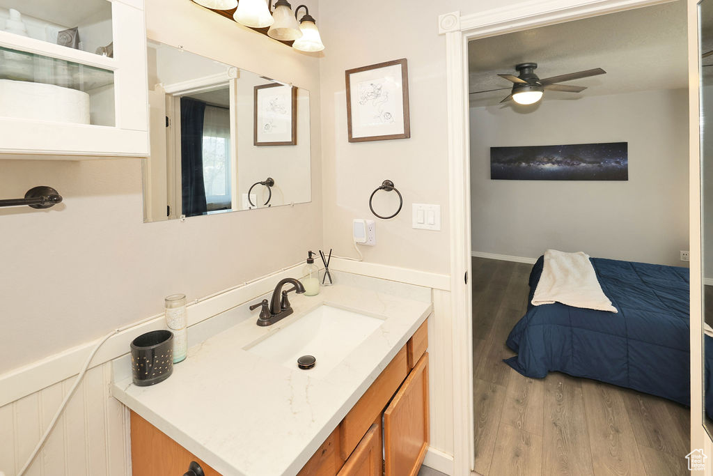 Bathroom featuring a ceiling fan, vanity, and wood finished floors
