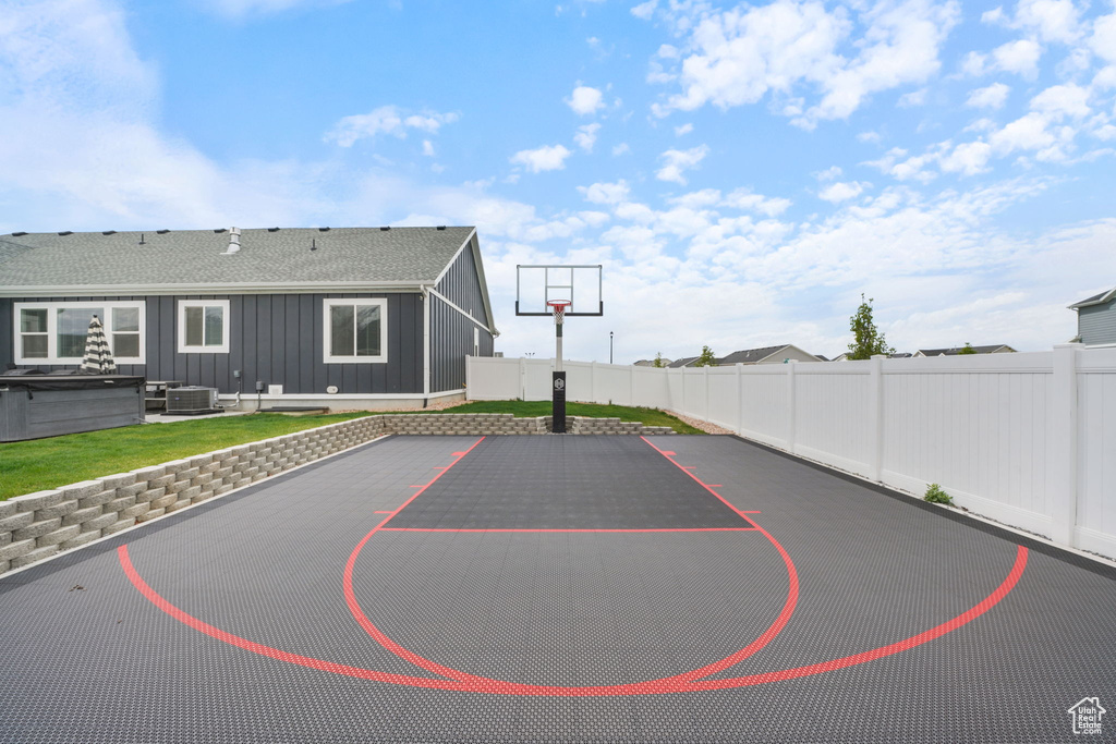 View of basketball court with basketball court and a fenced backyard