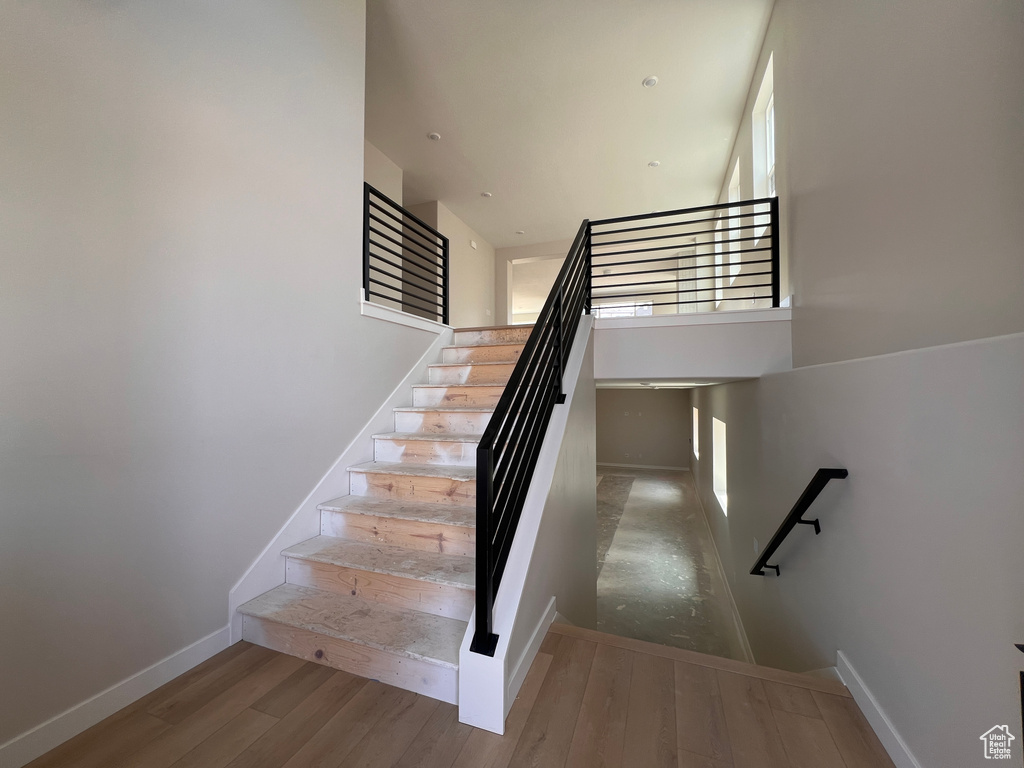 Stairway with wood finished floors and healthy amount of natural light