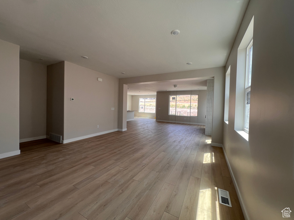 Unfurnished living room with wood finished floors and baseboards
