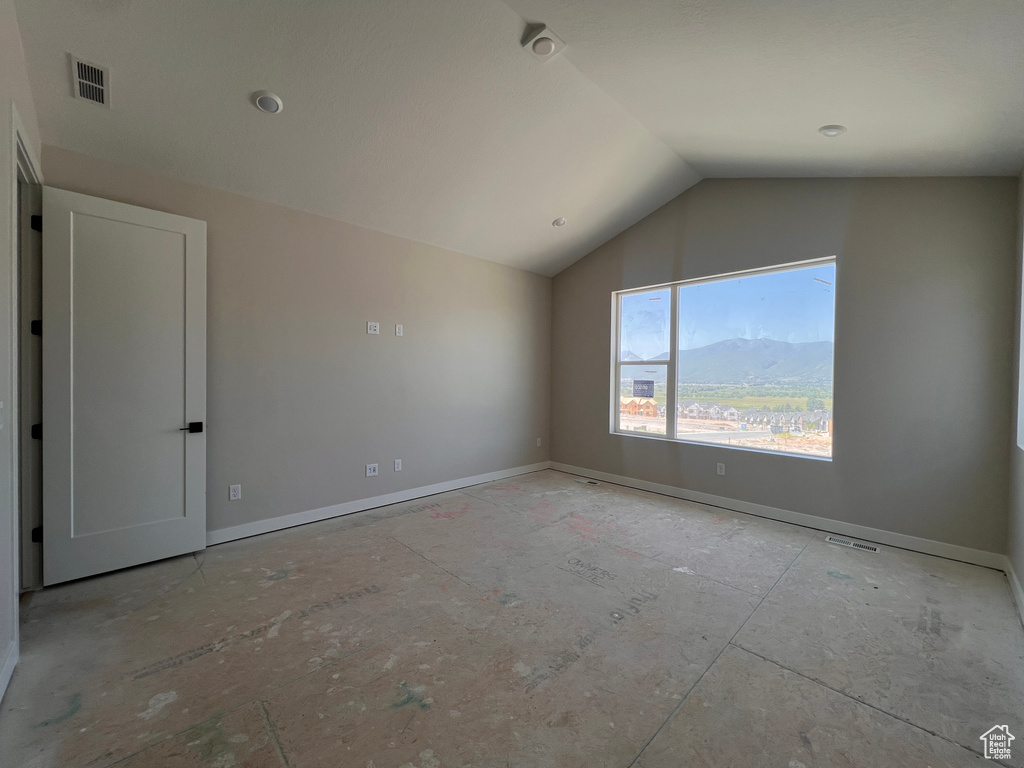 Empty room featuring lofted ceiling and a mountain view