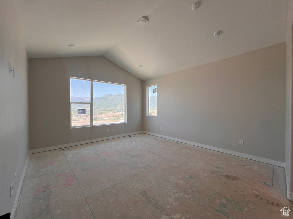 Unfurnished room with lofted ceiling and a smoke detector