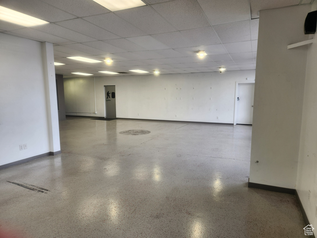 Unfurnished room with a drop ceiling and speckled floor