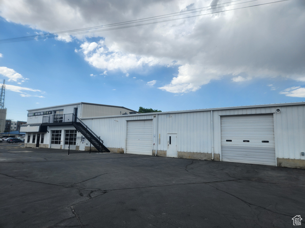 View of property featuring a garage and stairway