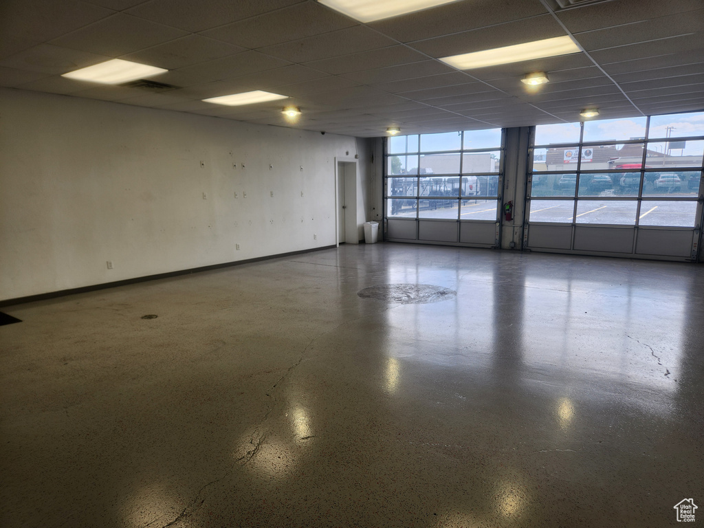 Empty room featuring a drop ceiling and baseboards