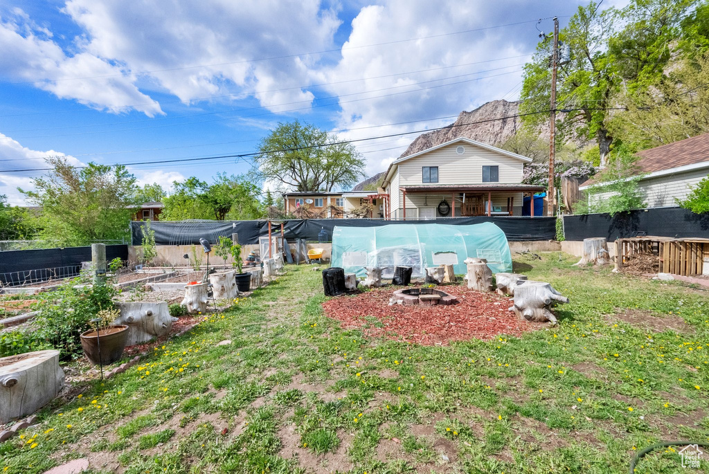 View of yard with an outdoor fire pit, fence, and a vegetable garden