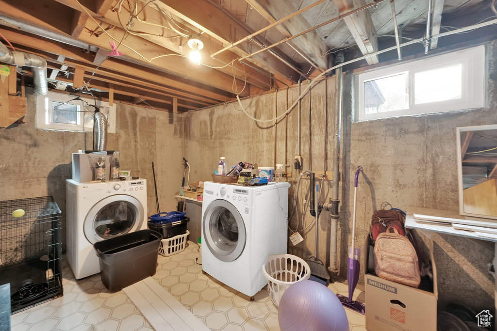 Clothes washing area featuring separate washer and dryer, laundry area, and tile patterned flooring