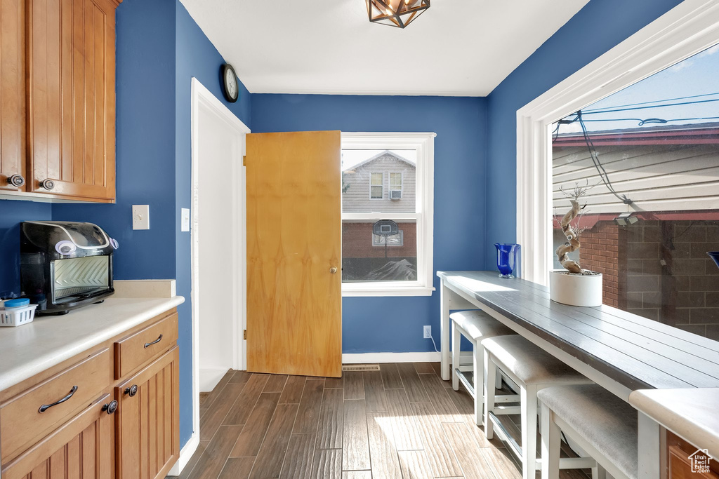 Dining area with baseboards and dark wood-style flooring