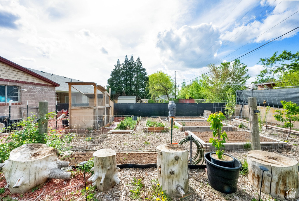 View of yard with fence and a vegetable garden
