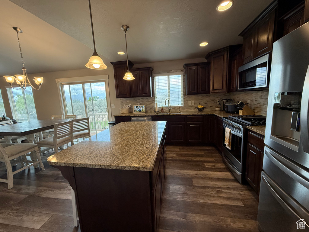 Kitchen with stainless steel appliances, a sink, dark brown cabinets, backsplash, and recessed lighting