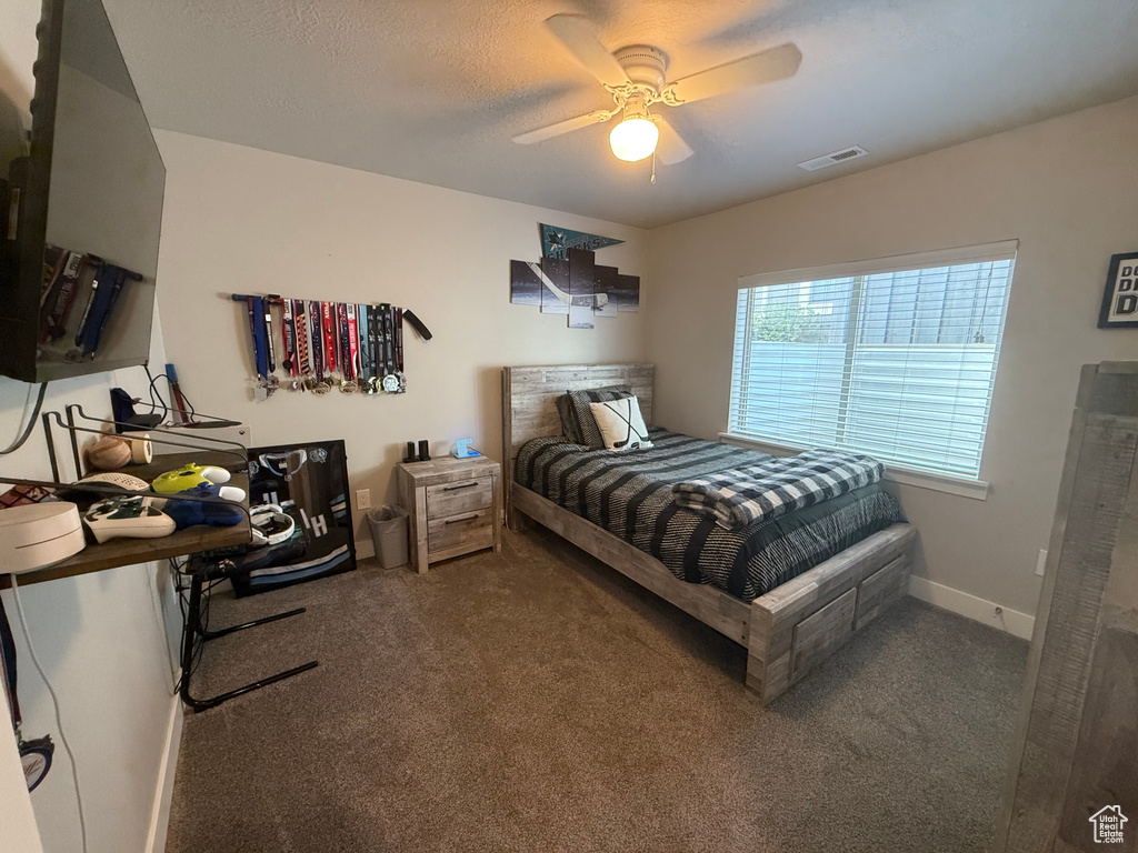 Carpeted bedroom featuring baseboards, a ceiling fan, and visible vents