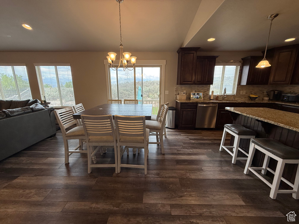 Dining space with dark wood-style flooring, a chandelier, recessed lighting, and vaulted ceiling