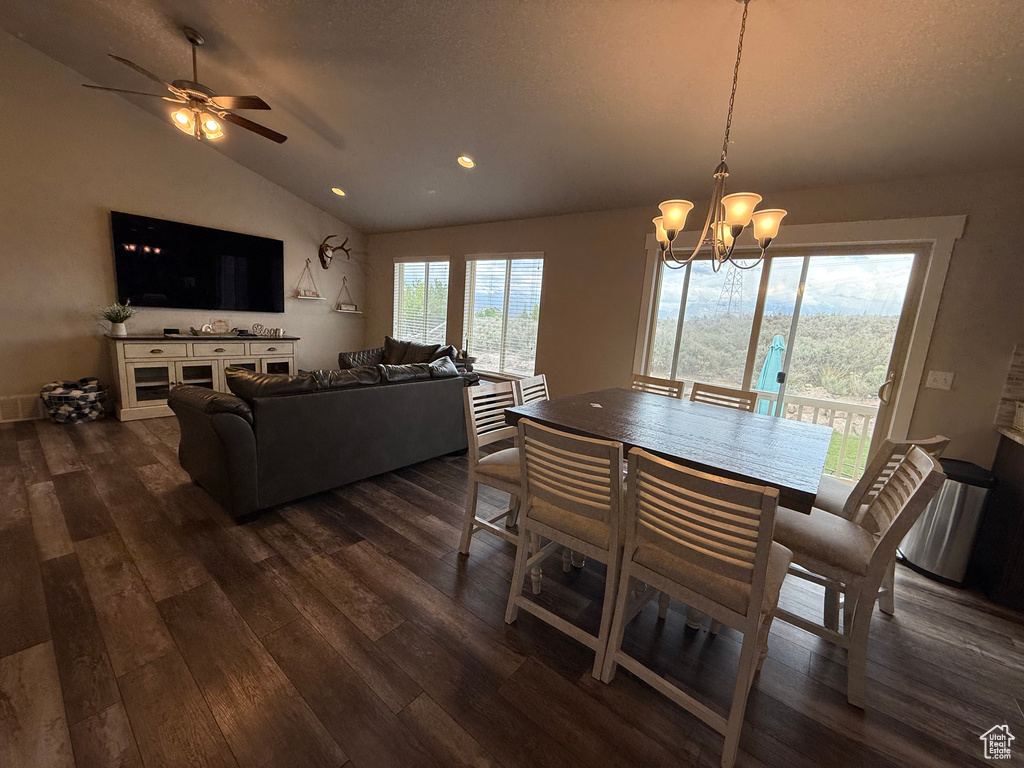 Dining room with dark wood-type flooring, vaulted ceiling, a chandelier, recessed lighting, and ceiling fan