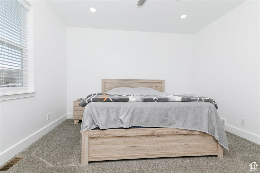 Bedroom featuring baseboards, visible vents, carpet floors, and ceiling fan