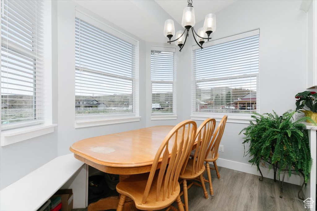 Dining room with light wood-style flooring and an inviting chandelier