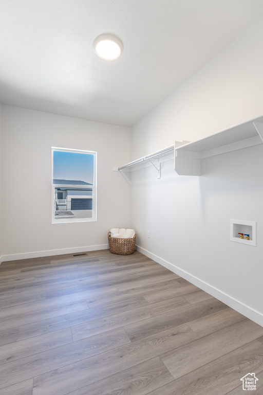 Walk in closet with wood finished floors