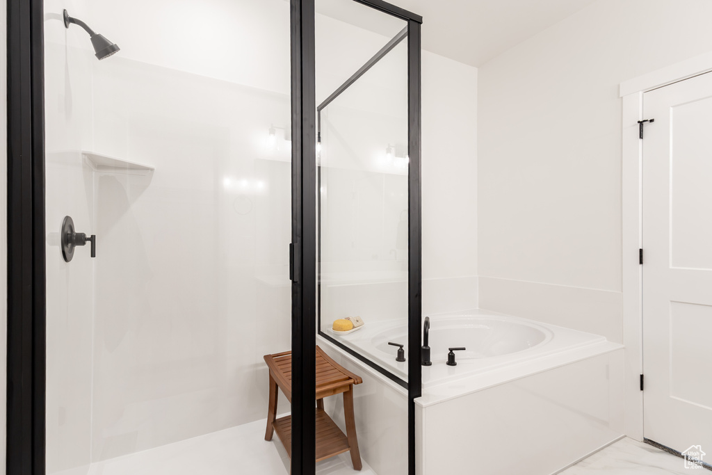 Full bathroom featuring a shower stall and a bath