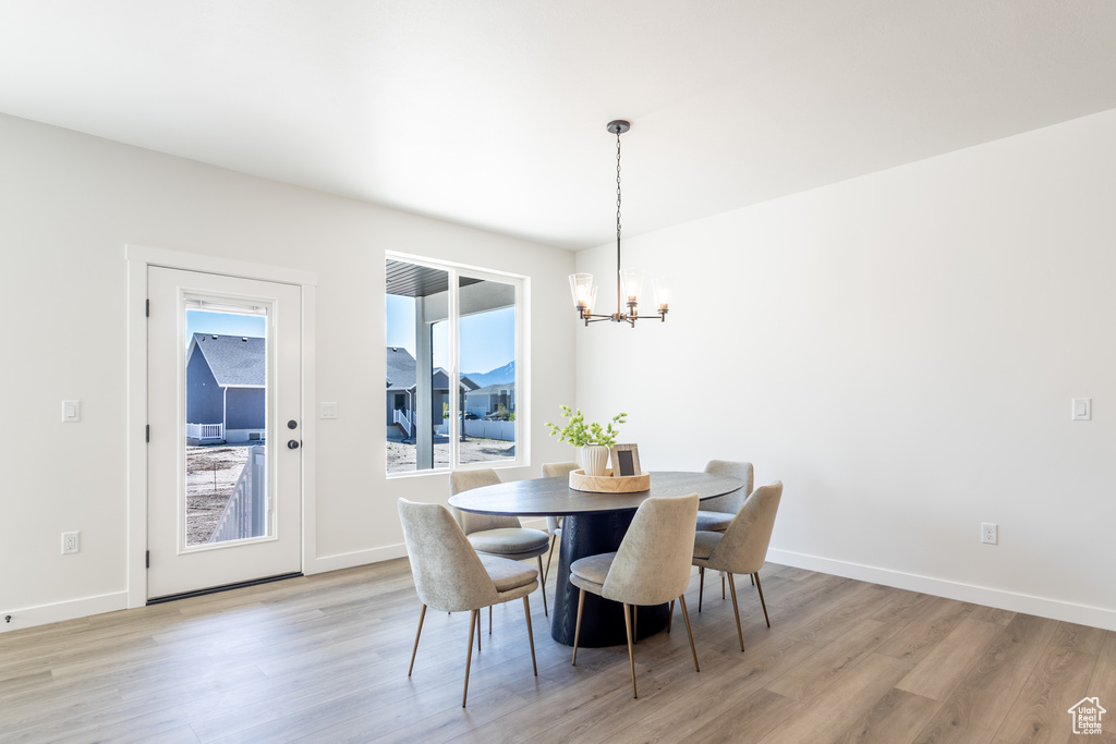 Dining area featuring a chandelier, light wood finished floors, and baseboards