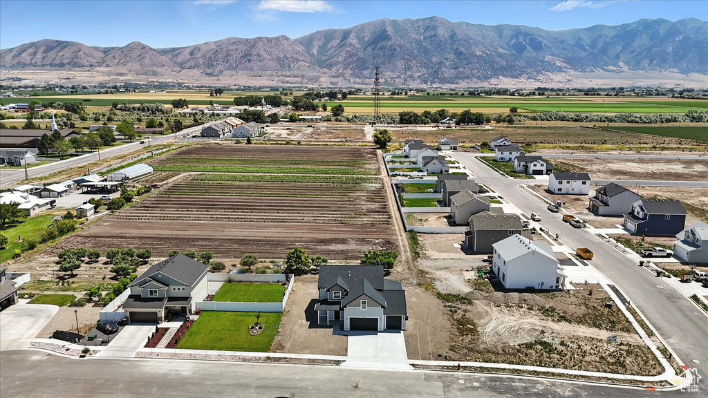 Aerial view of sparsely populated area with mountains and rows of crops