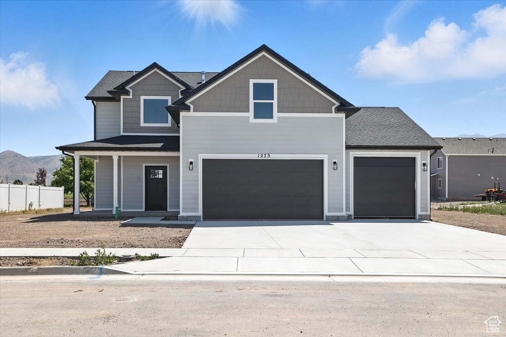 Craftsman-style home featuring driveway, a porch, a garage, and a mountain view