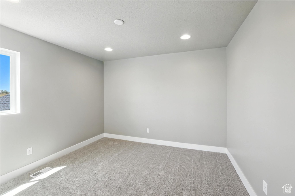 Unfurnished room with carpet floors, recessed lighting, and a textured ceiling