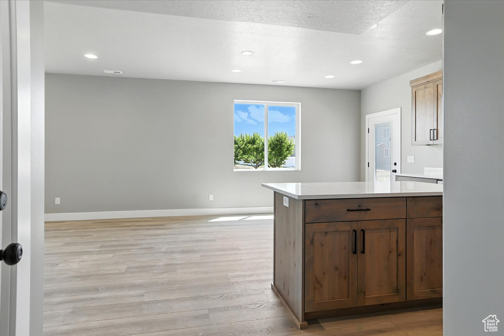 Kitchen with light wood finished floors, light countertops, and recessed lighting