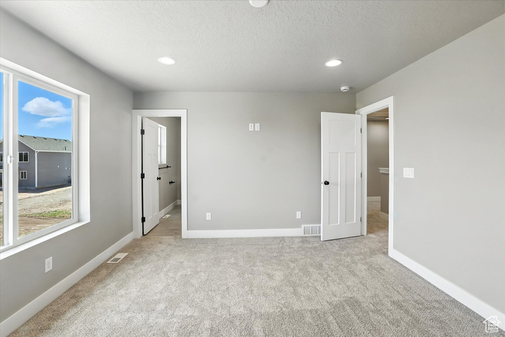 Unfurnished bedroom with carpet floors, a textured ceiling, and recessed lighting