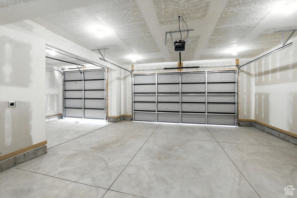 Garage with baseboards and a garage door opener