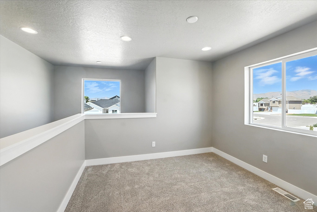 Carpeted spare room featuring recessed lighting and a textured ceiling